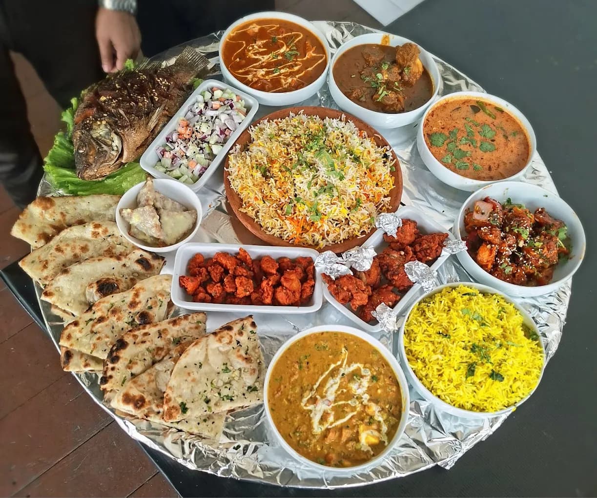 Hyderabadi thali featuring biryani, kebabs, and curries